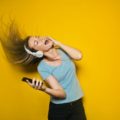 Žena poslouchá hudbu přes bezdrátová sluchátka, dodavatelé elektřiny 2021